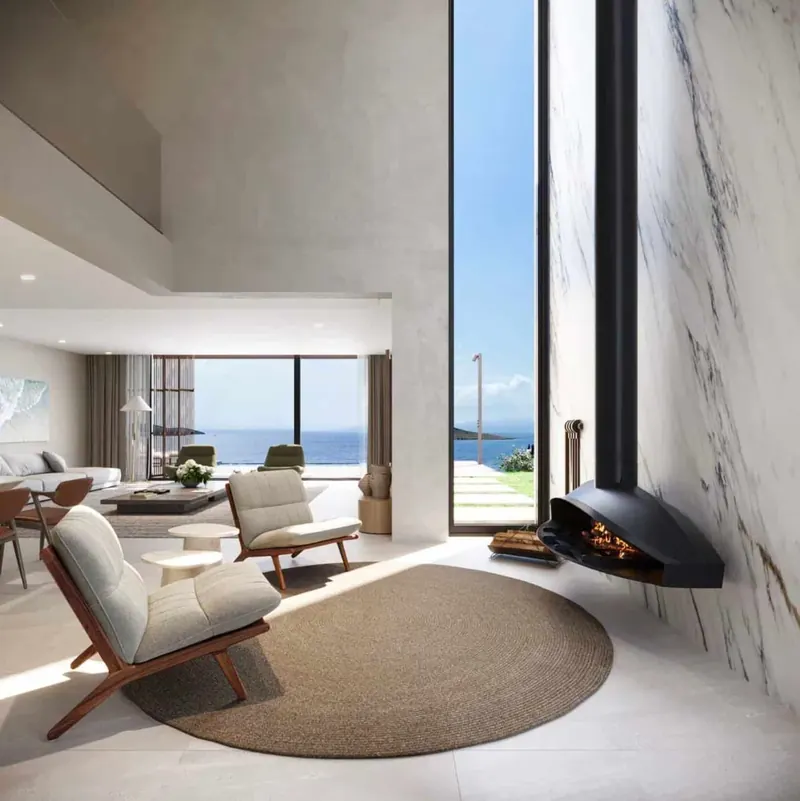 Ovoo Bodrum residence double-height lounge with a suspended fireplace, marble wall and sea view