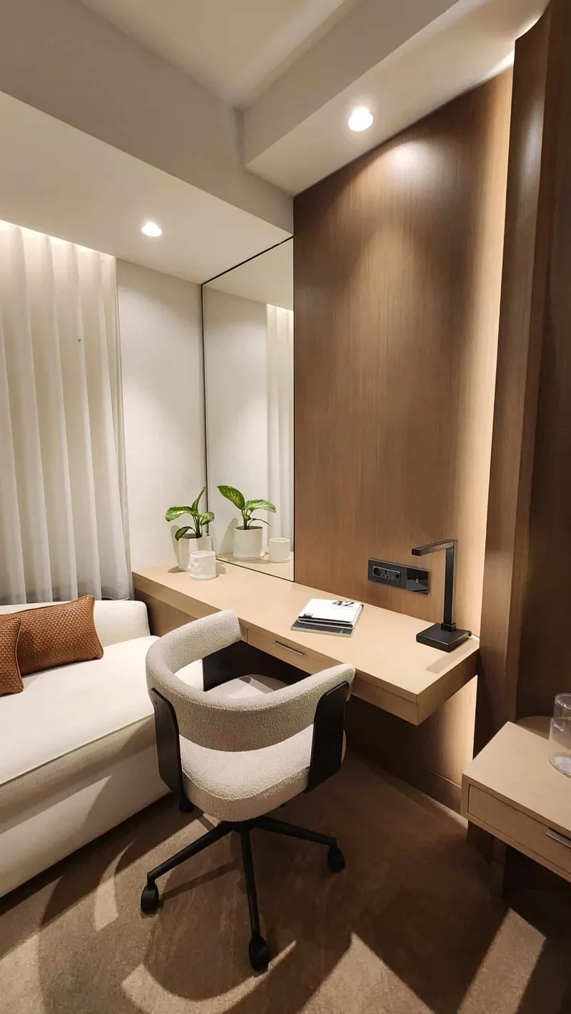 Prototype guest room with a timber desk, upholstered lounge seat and wall-mounted joinery